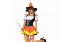 Fancy Witch Dress Ideas for Halloween Holiday Season Woman wearing a playful Kandy Korn witch costume featuring an orange, yellow, and white tiered skirt, thigh-high striped socks, a pointed hat, and holding a broom stick.