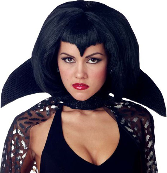 A woman in a vampire costume with a bob hairstyle, sharp bangs, and a high black collar. She has bold red lipstick and a confident expression.