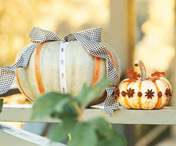 No-Carve-Gingham-Ribbon-And-Star-Anise-Pumpkins A pale green pumpkin wrapped in ribbons with a large gingham bow next to a small orange tiger pumpkin decorated with star anise pods.