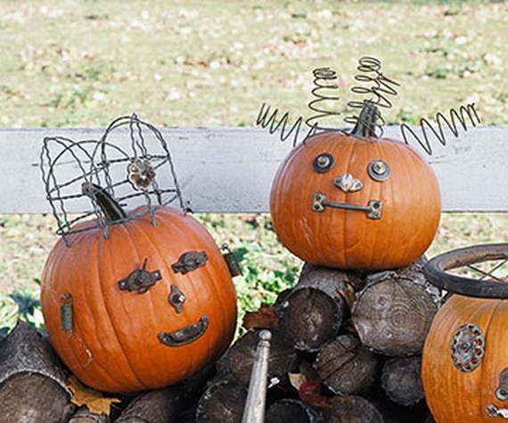 p_-_08 Two orange pumpkins decorated as funny faces with industrial junk, one featuring a wire basket crown and the other displaying coiled mattress springs as hair.