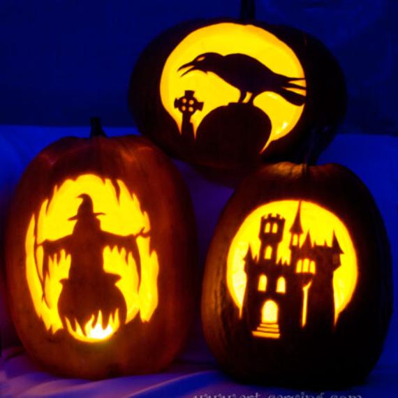 Three jack-o'-lanterns with intricate carvings: a raven on a gravestone, a witch over fire, and a haunted castle, all glowing warmly in dim light.