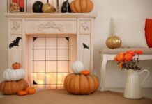 30 Elegant Halloween Décor Ideas for the Mantel A cozy fireplace adorned with pumpkins and flickering candles in front, creating a warm autumn atmosphere.
