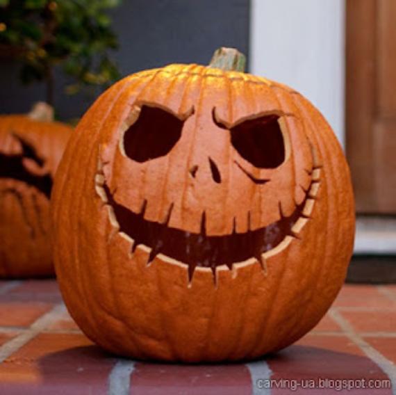 A Creative Pumpkin Carving sits on a brick porch, featuring a toothy grin and hollow eyes, evoking a spooky Halloween vibe. Another pumpkin is blurred in the background.