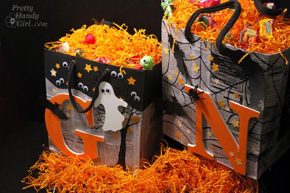 Halloween-themed gift bags filled with orange shredded paper, small toys, and candy. Each bag is decorated with googly eyes, stars, and black handles.