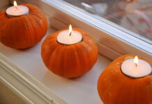 Halloween Candles for Creating Creepy Atmosphere Ideas Three real mini pumpkins hollowed out to hold lit white tea light candles on a white windowsill.
