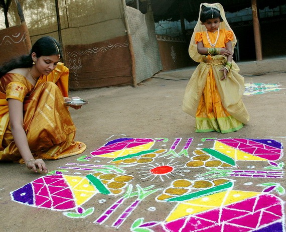 An Indian women applies coloured powder