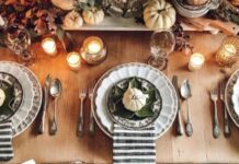 55 Elegant and stylish Black And White Thanksgiving Décor Ideas Three elegant place settings on a wooden table with striped napkins, small pumpkins, and candles, creating a warm, autumnal ambiance.