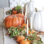 a-beautiful-and-natural-fall-centerpiece-of-green-blooms-fall-leaves-gourds-and-pumpkins-and-thin-and-tall-candles