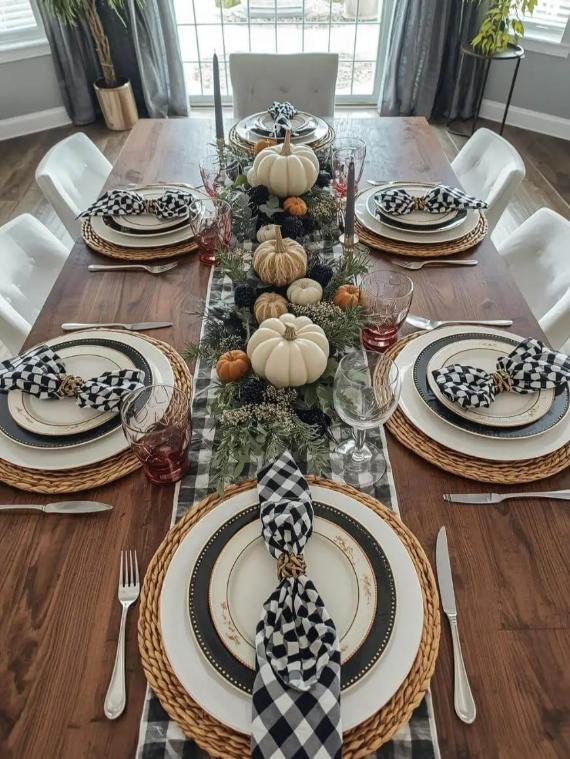 A formal table setting with autumnal decorations and checkered napkins.
