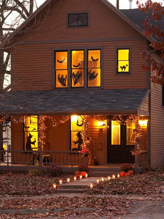 A house adorned with Halloween decorations, featuring glowing lights in the windows, creating a festive atmosphere.