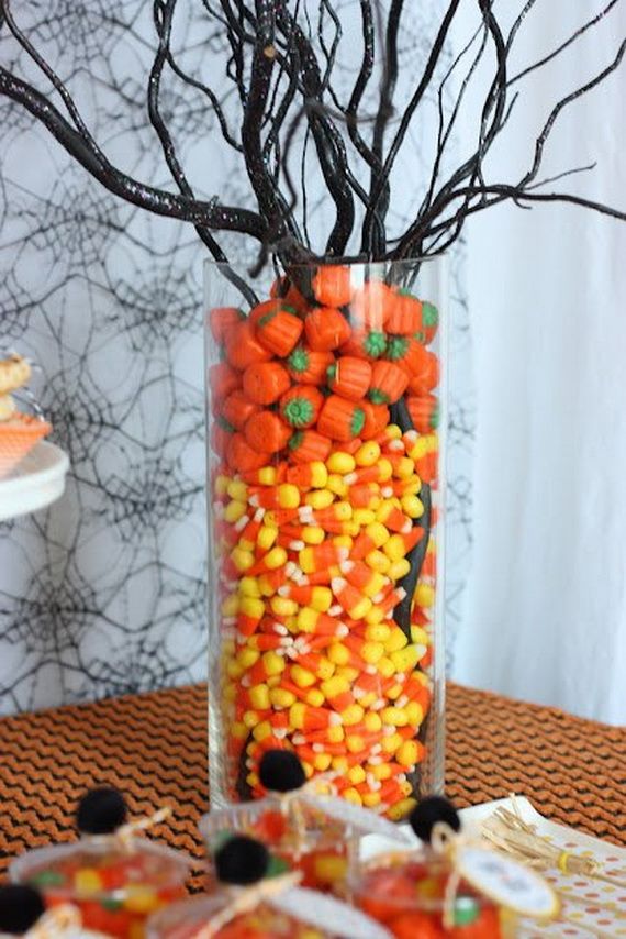  A clear vase filled with colorful candy and candy corn, creating a festive and cheerful display.