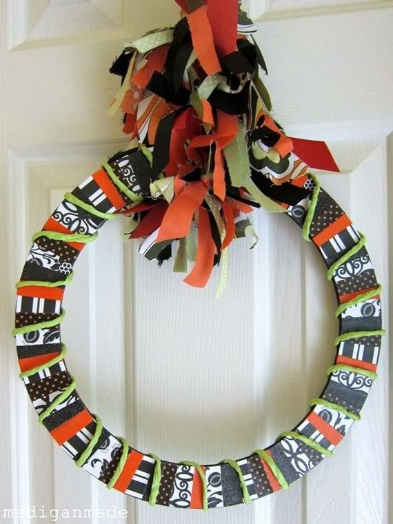A Halloween wreath crafted from colorful paper and ribbon, featuring festive decorations for the holiday season.