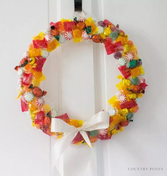 A festive wreath crafted from colorful candy and candy canes, perfect for holiday decorations.