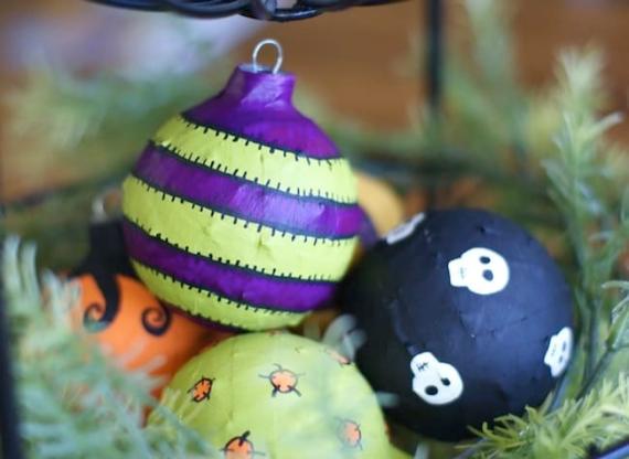 A basket filled with Halloween decorations surrounded by green leaves, showcasing festive colors and themes.