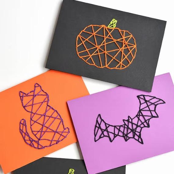 A collection of colorful paper cut-out witches attached to sticks, arranged for a festive display.