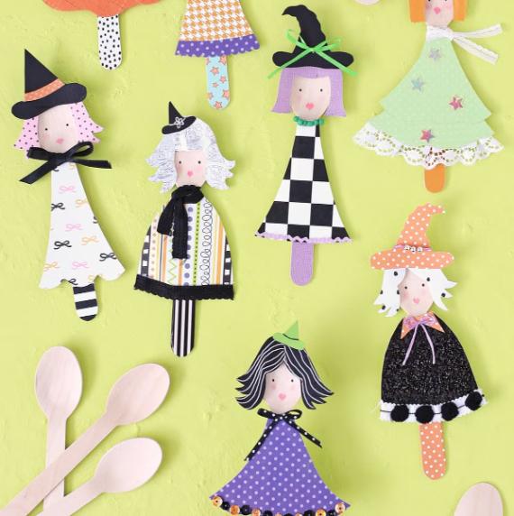  collection of colorful paper cut-out witches attached to sticks, arranged for a festive display.