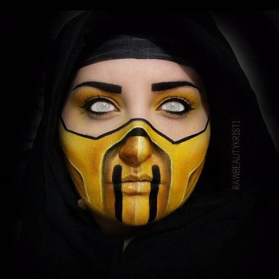 Intense Scorpion Halloween Makeup of a person with intense face paint, resembling a yellow and black mask, set against a dark hood. The eyes are strikingly white, creating a mysterious and bold visual effect.