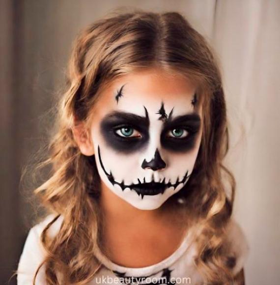 Young child with intricate skeleton face paint, featuring Vampire Face with dark eyes and a detailed, eerie expression. The tone is spooky yet playful.