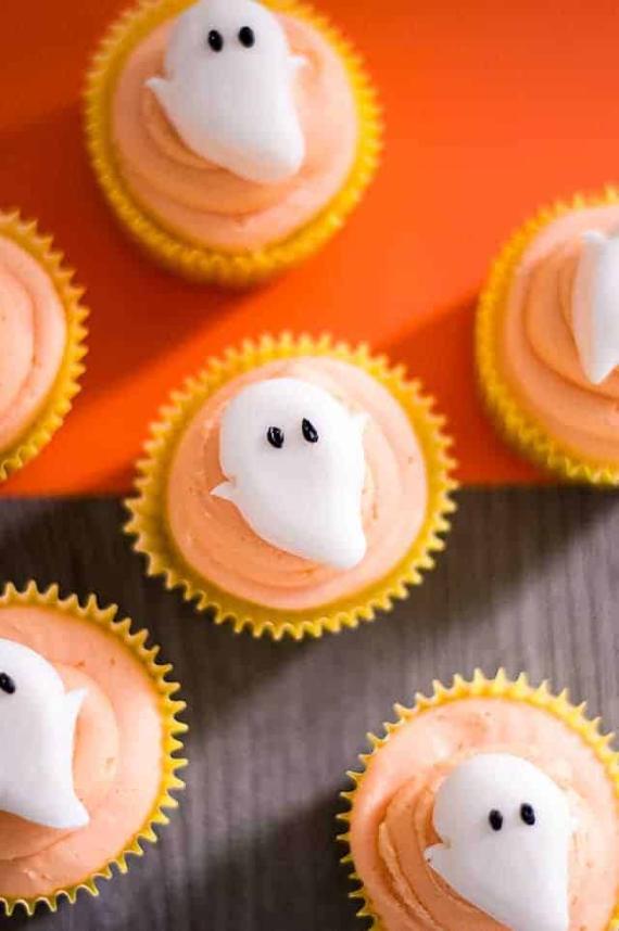 Halloween-themed cupcakes topped with playful ghost faces, decorated for a festive celebration.
