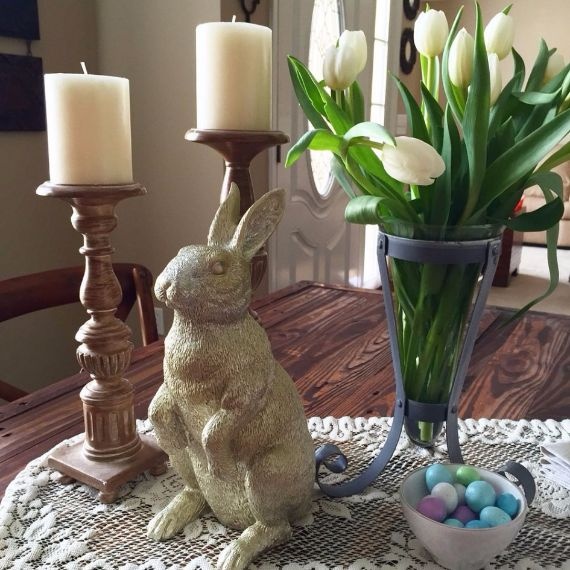adorable-easter-holiday-decor_gold-ceramic-bunny-figurine_brown-metal-candle-stand_unique-blue-metal-vase_alluring-flower-arrangement_white-lace-table-runner-mu