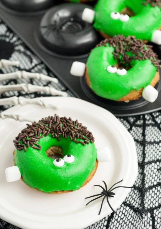 Assorted Halloween donuts featuring vibrant green frosting and a variety of sprinkles, ideal for seasonal treats.