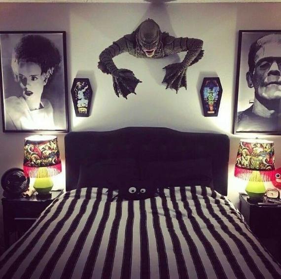 A bedroom featuring black and white striped bedding and a decorative monster head mounted on the wall.