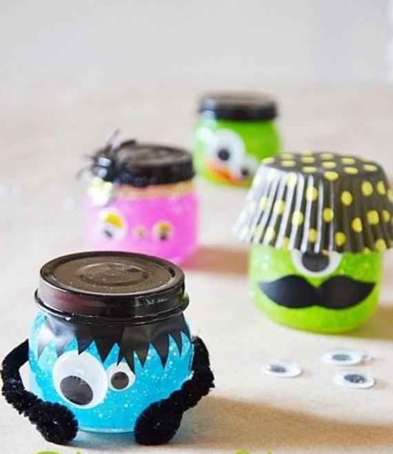 Four colorful jars decorated as playful monsters. Blue one with headphones, pink one with eyes and bow, green one with mustache, and another green with one eye and spots.