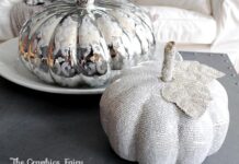 Decoupage Pumpkin to Match Your Décor Two decorative pumpkins on a table; one is silver with a reflective surface, the other is made of newspaper with a glittery leaf, conveying a festive, artistic vibe.