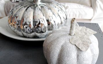 Decoupage Pumpkin to Match Your Décor Two decorative pumpkins on a table; one is silver with a reflective surface, the other is made of newspaper with a glittery leaf, conveying a festive, artistic vibe.