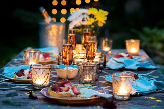 Foto de Decoration tulips flowers, decor candles. Candlelight dinner setup  table for couple on Valentine's day. Table setting in the restaurant.  Luxury romantic date. Location for surprise marriage proposal. do Stock |