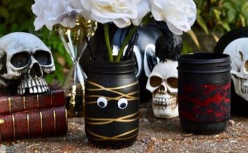30 Impressive DIY Mason Jar Halloween Crafts Ideas to Spice Up Your Fall Decor Halloween-themed jars filled with skulls and vibrant flowers, creating a festive and spooky atmosphere.