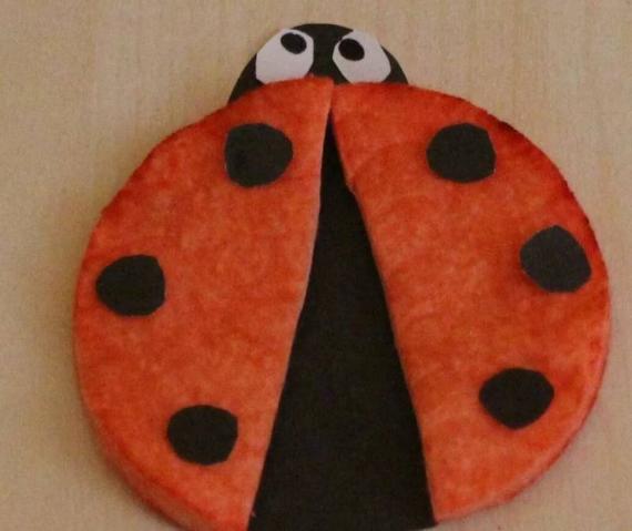 Crafted Ladybug Cotton Pad Craft with an open shell showing a black inner body. The wings are red with black spots, and the head has large eyes, giving a playful vibe.