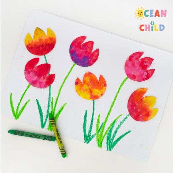 Colorful, childlike drawing of tulips with red, orange, and pink hues made from cotton pad. Green stems and leaves are scribbled with crayons. Fun and playful vibe.