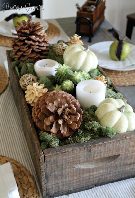 A wooden crate filled with pine cones, pineapples, and various fall decorations, showcasing autumn's vibrant colors.