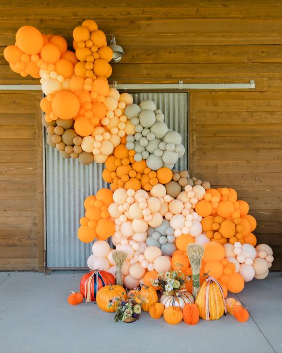 A festive arch made of colorful pumpkins, creating a vibrant autumn display for a seasonal celebration.