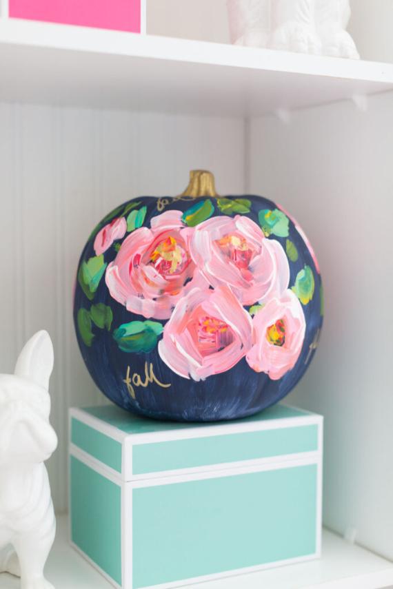 A decorative pumpkin, painted in bright hues, sits on a blue box, adding a festive touch to the scene.