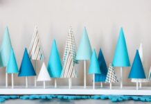 CHRISTMAS PARTY IDEAS FOR KIDS A collection of blue and white cone-shaped paper trees on a white base.
