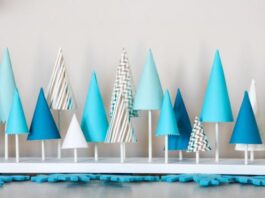 CHRISTMAS PARTY IDEAS FOR KIDS A collection of blue and white cone-shaped paper trees on a white base.