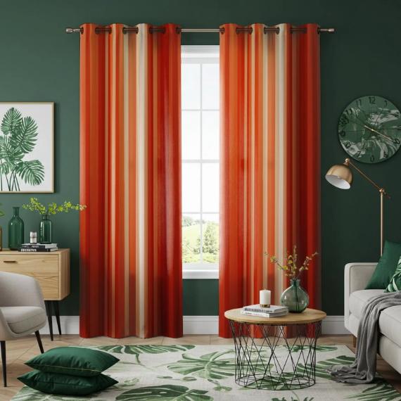 A cozy living room with vibrant orange-striped curtains framing a window are an unexpected fall color schemes. Green walls, leafy decor on the walls, and a matching rug enhance the room's natural theme.