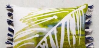 11 Easy decorative Handmade Appealing Printed Pillow Ideas A rectangular pillow with an abstract leaf pattern in green and white, featuring blue tassels on the sides. The design is fresh and vibrant.