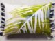 11 Easy decorative Handmade Appealing Printed Pillow Ideas A rectangular pillow with an abstract leaf pattern in green and white, featuring blue tassels on the sides. The design is fresh and vibrant.
