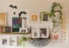 DIY & Outdoor Halloween Curb Appeal Guide A cozy wall display features framed art, a shelf with books, and a hanging plant. Black paper bats and a web add a playful, Halloween touch.