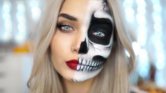 A woman with half her face painted as a skeleton, featuring intricate black and white details. The other half has makeup with bold red lipstick.